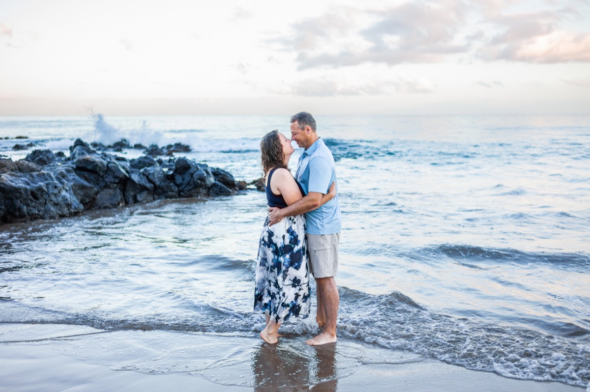 A couple embracing at the shoreline during a recent Maui Mini Session